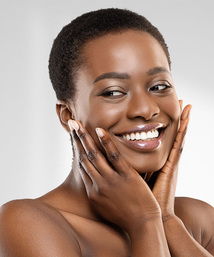 Beautiful African American woman smiling and touching her face | Dermal Fillers | Delmar Family Medicine Aesthetics