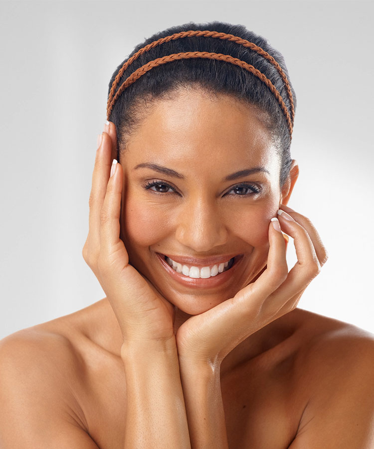 Beautiful African American woman smiling and touching her face | Laser Treatment | Delmar Family Medicine Aesthetics